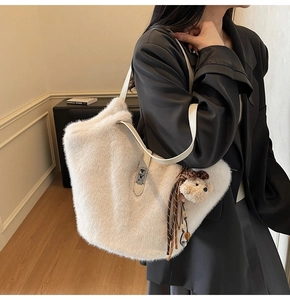 Détail du sac cabas en fausse fourrure blanc cassé avec bandoulière et bijou d'ours