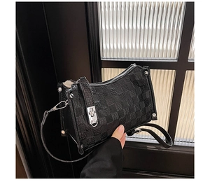 Detail of black checkerboard embossed leather handbag with silver stud accents