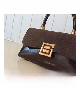 Detail der dunkelbraunen Patchwork-Handtasche mit goldener Schnalle und Lederstruktur
