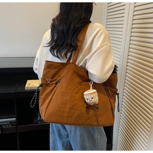 Détail du sac fourre-tout en toile avec cordon de serrage et breloque en peluche tasse à café