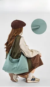 Detail view of mint green washed canvas crossbody bag with drawstring dumpling design