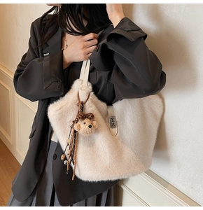 Détail du sac seau en fausse fourrure douce avec bandoulière et breloque ourson