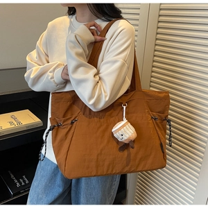 Détail du grand sac cabas caramel avec cordons latéraux et pendentif en peluche mignon
