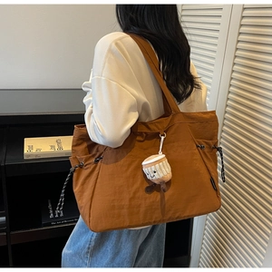 Détail du grand sac cabas en nylon marron avec cordon et pendentif en tricot mignon
