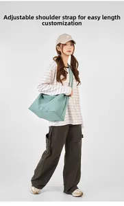Detail of adjustable wide shoulder strap on large mint green crossbody tote bag