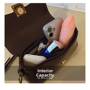 Detailansicht der Innenkapazität mit Handy und Kosmetika in der braunen Handtasche