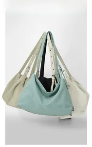 Detail of adjustable wide shoulder straps and metal eyelets on various nylon tote bags