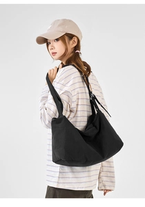Detail view of large black nylon tote bag showing pleated texture and spacious design