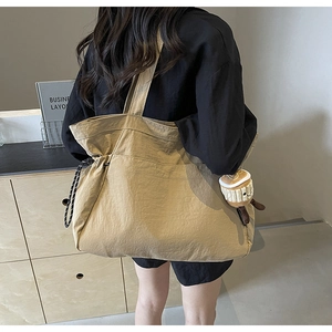 Détail du sac cabas kaki avec cordon de serrage et charmant pendentif peluche