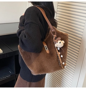 Détail du sac seau en peluche marron avec bandoulière en cuir et pendentif ours