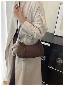 Detailaufnahme der braunen Wildleder-Hobo-Tasche mit flauschigem Hasenanhänger und Textur