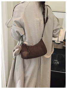 Retro dunkelbraune Wildleder-Tasche mit süßem Plüschhasen-Anhänger an einem Modell