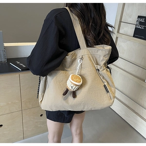 Détail du sac cabas kaki avec cordons de serrage et charmant porte-clés tasse à café