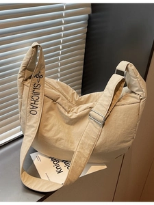 Large beige quilted nylon hobo bag with adjustable wide logo strap for casual daily commuting