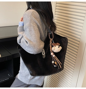 Détail du sac seau noir en fausse fourrure pelucheuse avec breloque ours et perles