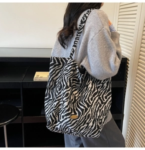 Detail shot of a large zebra print tote bag with handmade label on knitted fabric