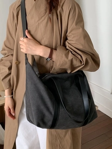 Grand sac cabas en toile anthracite avec lanières en cuir porté par un mannequin chic