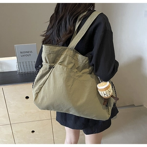 Détail du sac cabas en nylon vert olive avec poche à cordon et breloque en peluche