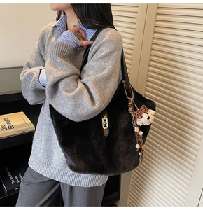 Détail du cabas en fausse fourrure noire avec breloque ours et élégants pompons perlés