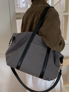 Grand sac cabas en toile grise avec anses noires et poches latérales porté par mannequin