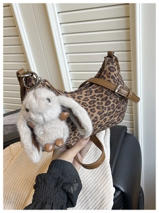 Detailansicht der sichelförmigen Tasche mit Leopardenmuster, Lederbesatz und Plüsch-Anhänger