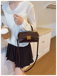 Detailansicht der dunkelbraunen Handtasche mit Goldschnalle und elegantem Griff
