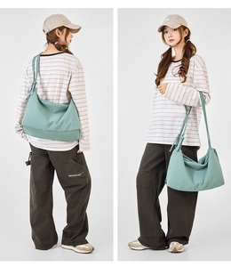 Detail of light green canvas crossbody bag showing texture and adjustable strap