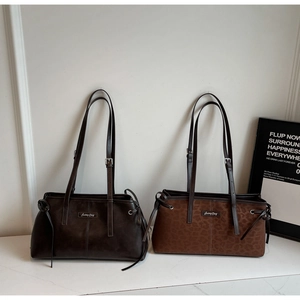Detail view of brown and leopard print shoulder bags with adjustable straps on marble
