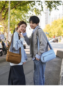 Detail showing deep brown and sky blue nylon shoulder bags with wide straps