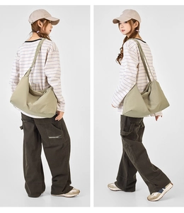 Detail view of olive green large capacity crossbody bag with stylish pleated drawstring design