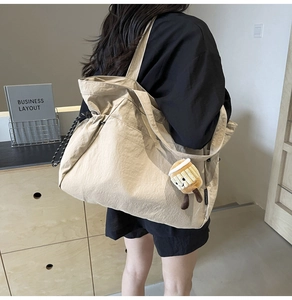 Détail du grand sac cabas beige avec fermeture à cordon et breloque cupcake en peluche