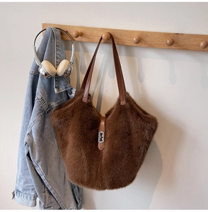 Détail du sac seau marron en fausse fourrure avec lanières en cuir et boucle en métal