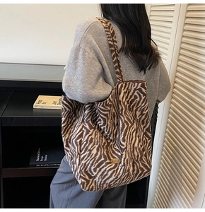 Detail of animal print tote bag with Handmade metal tag on textured fabric