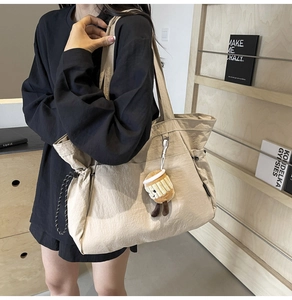 Détail du grand sac cabas beige avec cordon de serrage et charm en peluche tasse à café