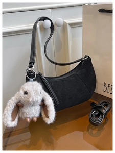 Details der schwarzen Wildleder-Tasche mit flauschigem Langohr-Hasen Plüsch-Anhänger
