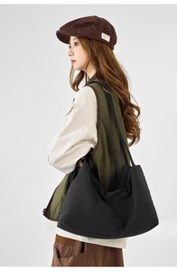 Side view of a large black nylon tote bag on a model in Japanese workwear style outfit