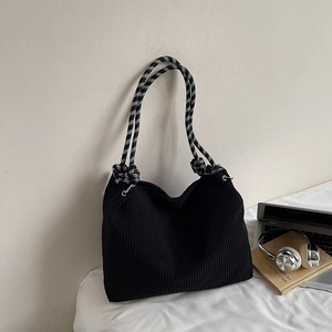 Detail of black corduroy tote bag with black and white checkerboard rope handles
