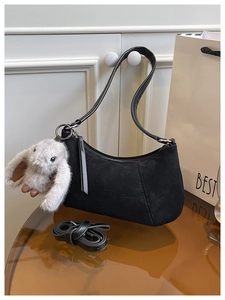 Detailansicht der schwarzen Wildledertasche mit silbernem Ring und Plüschhasen-Anhänger