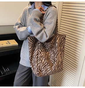 Detail view of the zebra print shoulder tote bag with a handmade label and soft texture