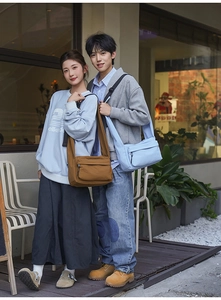 Outdoor shot of large canvas messenger bags in coffee and sky blue for commuters