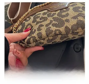 Detailed close-up showing the quality stitching and leopard print fabric of the crossbody bag