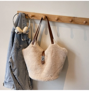Détail d'un sac en fausse fourrure beige avec boucle en métal argenté et bandoulière en cuir