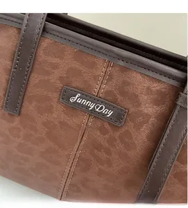 Close-up of retro brown frosted pillow bag featuring Sunny Day leather label and fine stitching