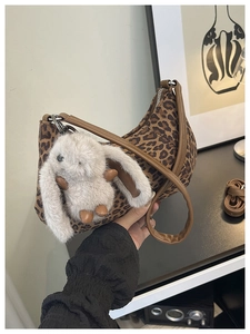 Detail der Vintage-Tasche mit Leopardenmuster und niedlichem Plüsch-Hasen-Anhänger