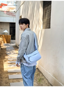 Close-up of a light blue nylon crossbody messenger bag with waterproof fabric and wide strap