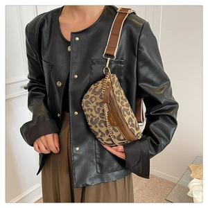 Close-up of leopard print crossbody bag with wide brown strap and gold chain detail