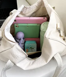 Vista interna che mostra la grande capacità della borsa tote beige con oggetti vari