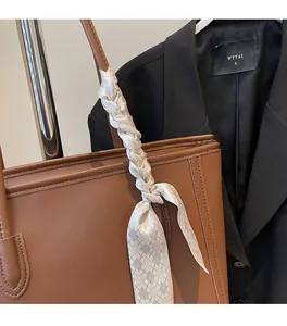 Brown leather tote bag featuring a checkered silk scarf wrapped around the handle detail