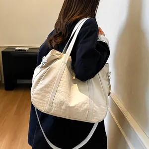 Modella che indossa una grande borsa tote crema in tela lavata per il tempo libero