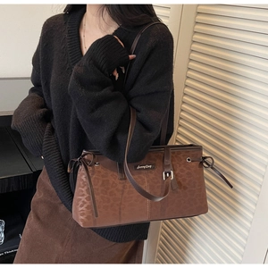 Brown leopard print shoulder bag with drawstring detail and metal nameplate on model